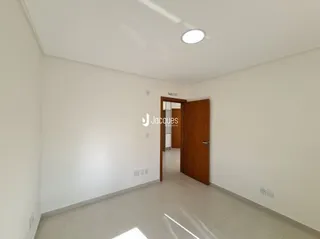 Hall de entrada com paredes brancas e piso claro.