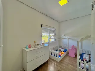 Quarto com berço e cômoda em ambiente claro.
