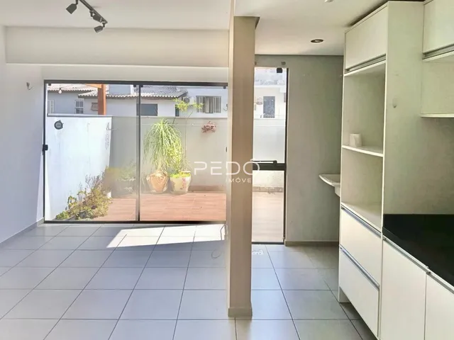 Sala de estar com porta de vidro abrindo para um pátio externo.