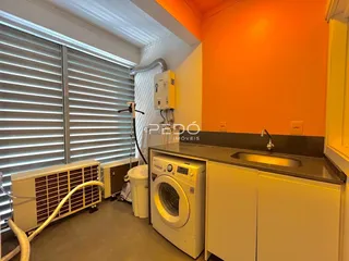 Foto de um ambiente interno mostrando uma área de serviço com máquina de lavar e vaso sanitário.