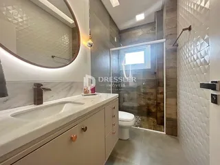 Banheiro moderno com revestimento branco e piso cinza claro.