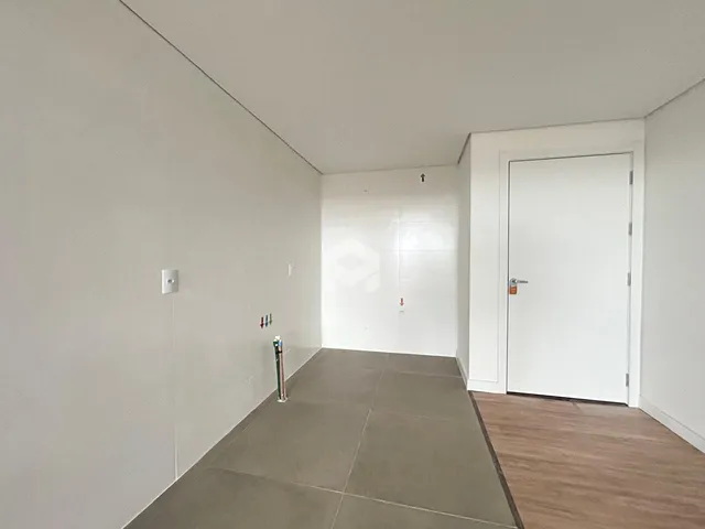 Hall de entrada com piso de concreto e paredes brancas.