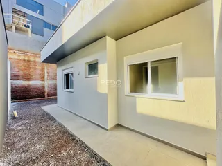 Fachada de uma residência em Lajeado, Brasil, mostrando a parede branca e o pátio externo.
