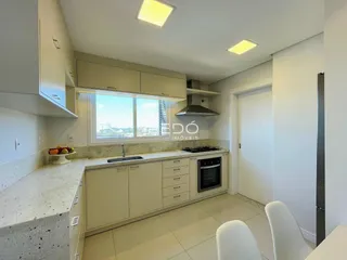 Cozinha moderna com bancadas claras e janela em um imóvel em Lajeado.
