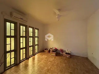 Ambiente interno com piso de cerâmica e janelas altas.
