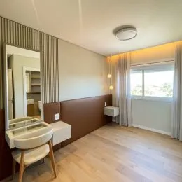Foto de um quarto com parede clara e espelho grande.