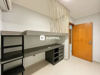 Foto de um ambiente interno com bancadas escuras e armários em uma residência.