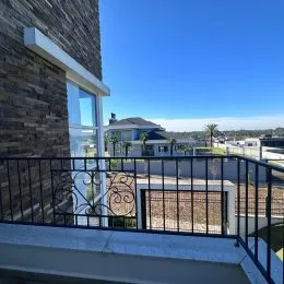 Vista externa da fachada de um imóvel com grade de ferro preta.