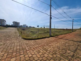 Vista externa de uma área pavimentada com tijolos vermelhos.