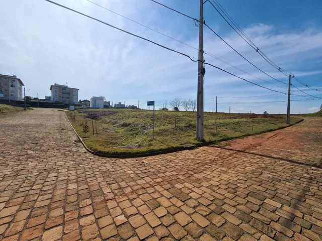 Vista externa de uma área pavimentada com tijolos vermelhos.