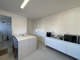Ambiente interno com mesa de jantar e móveis modernos em uma sala de estar.