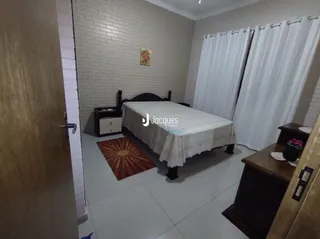 Quarto com cama e paredes brancas no imóvel.