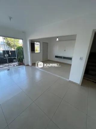 Foto de um ambiente interno com piso de cerâmica clara e porta de vidro.