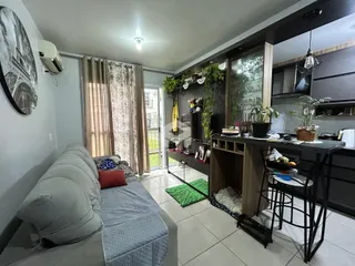 Sala de estar com sofá e cortinas em um imóvel no Brasil.