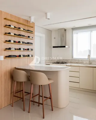 Imagem de uma cozinha moderna com ilha e armários de madeira clara.