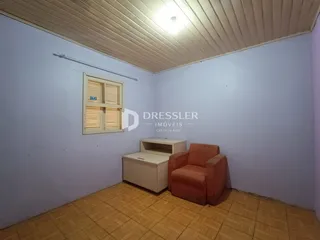 Ambiente interno de uma sala com piso de cerâmica e teto de madeira.