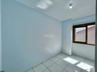 Parede interna de uma sala com piso de cerâmica branca.