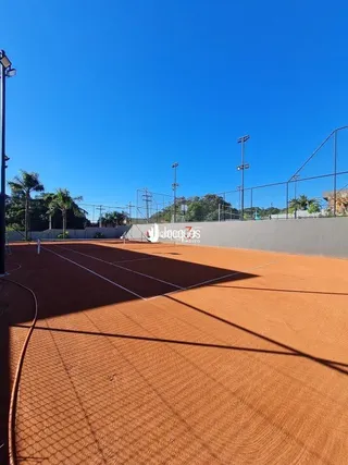 Vista aérea de uma área externa com piso avermelhado.