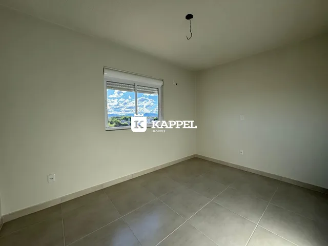 Foto de um cômodo interno com paredes brancas e piso de porcelanato.