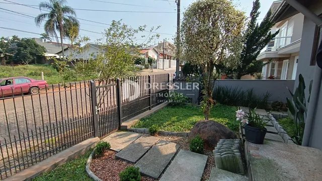 Vista externa de uma propriedade com cerca de ferro e jardim em Lajeado.