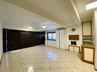 Sala de estar com piso de cerâmica e armários de madeira escura.