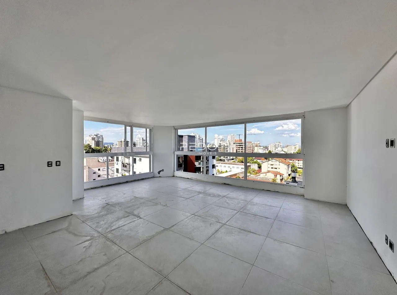 Ambiente amplo com piso de concreto e vista da cidade.