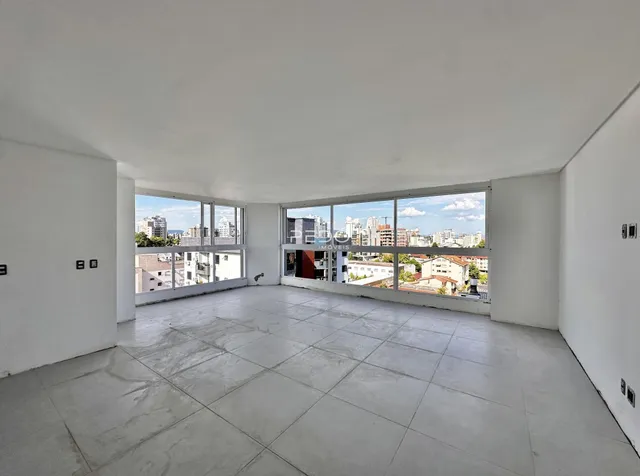 Ambiente amplo com piso de concreto e vista da cidade.