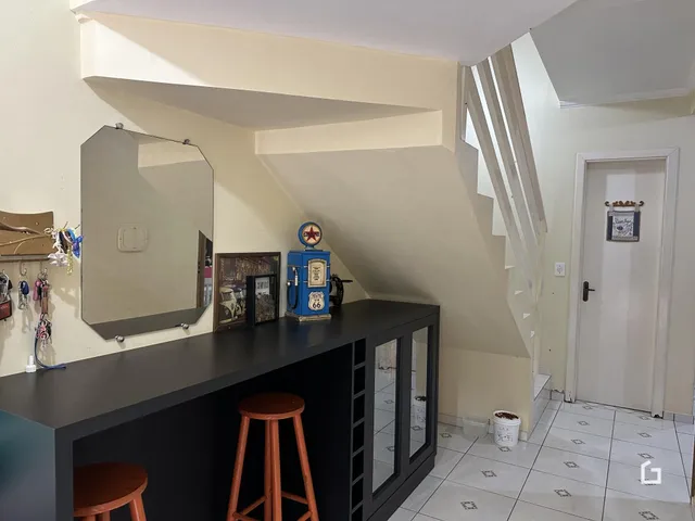 Hall com escadaria e espelho na área interna da residência.