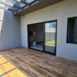 Vista de um piso de madeira e porta de vidro em um ambiente interno.