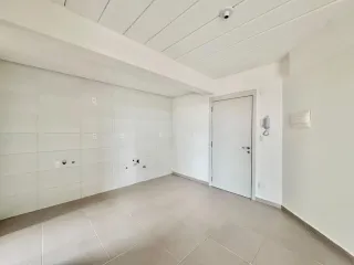 Sala de estar com paredes brancas e piso de cerâmica.