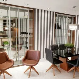 Sala de estar com paredes listradas e portas de vidro.