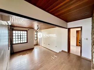 Sala de estar com piso de madeira e teto de madeira em um imóvel.