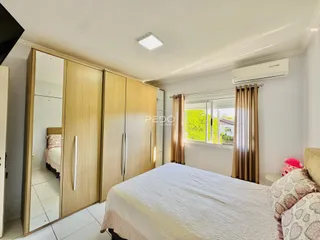Quarto com armários em madeira e janela.