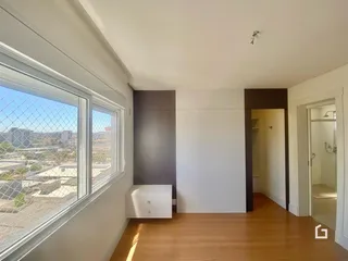 Ambiente interno com grande janela oferecendo vista da paisagem urbana.