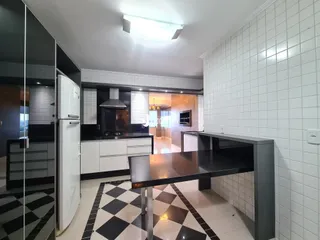Cozinha moderna com piso xadrez preto e branco e revestimento branco.