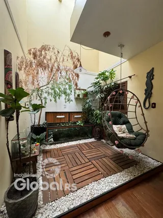 Sala com piso de madeira e decoração com plantas.