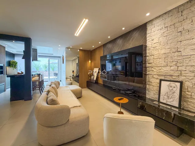 Sala de estar moderna com sofá e parede de destaque em Lajeado.