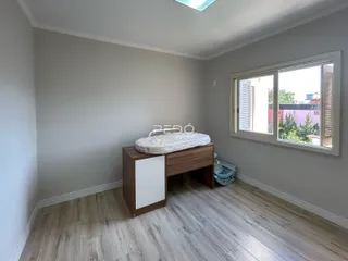A foto mostra um quarto com paredes cinzas e piso de madeira clara.