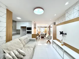 Sala de estar moderna com piso de cerâmica e móveis claros.