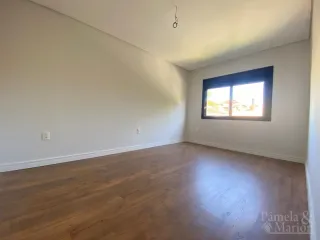 Ambiente interno com piso de madeira e janela visível.