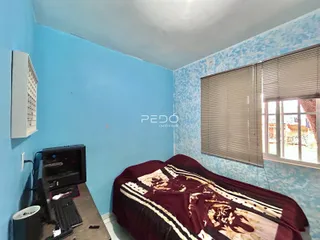 Quarto com paredes azuis e janela com persianas.