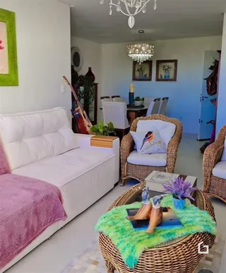 Sala de estar com sofá branco e móveis de vime.