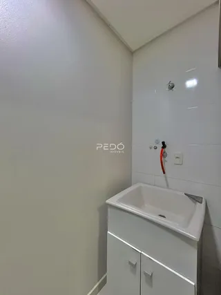 Foto de um banheiro moderno com bancada branca e revestimento cerâmico.