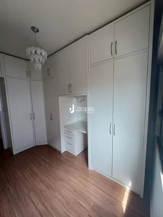 Quarto com armários embutidos e piso de madeira clara.