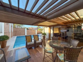 Área externa com piscina e mobiliário de jardim.