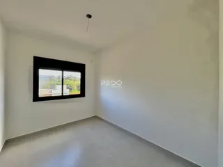 Ambiente interno de uma sala com paredes brancas e piso claro.