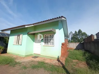 Fachada de uma casa em Lajeado, Brasil, com paredes verdes e telhado de telhas.