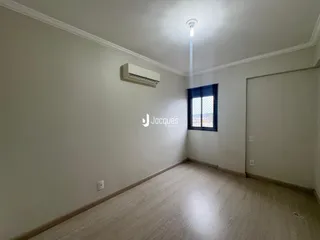 Ambiente interno de uma sala com piso de madeira e janela.