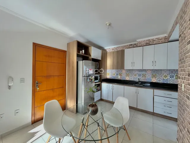 Interior de uma sala de jantar com móveis modernos e armários de cozinha.