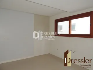 Interior de uma sala de estar com paredes brancas e piso claro.